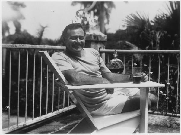 Ernest Hemingway sitting in a patio chair at his estate in Finca Vigia in Cuba