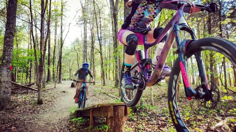 mountain bikers go over a ramp