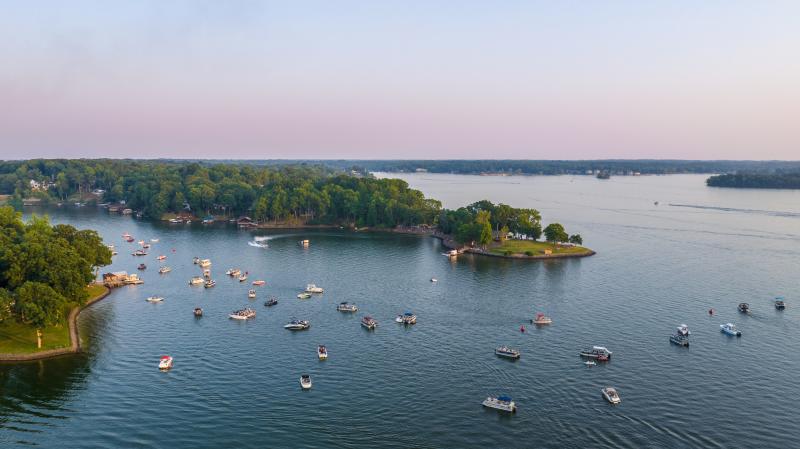 Lake with many boats on it with a piece of land seen
