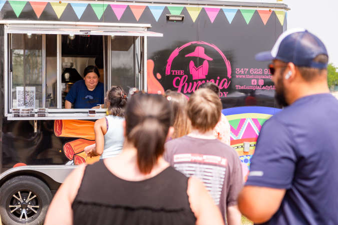 A food truck worker takes orders as a line forms in front of the truck during a Pleasant Prairie HarborMarket Event