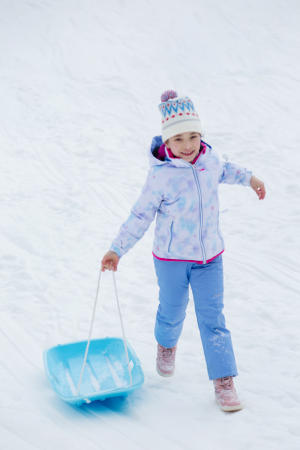 Small Girl Pulling Her Sled in the Snow