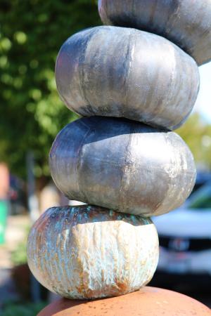 Sculpture with acorn shaped metal objects stacked up