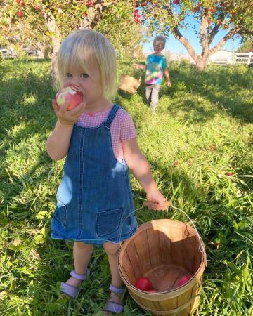 Girl Eating Apple at Orchard