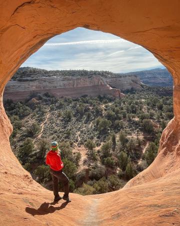 Woman Standing Under Cedar Tree Arch in Rattlesnake Canyon