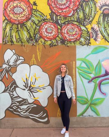 Woman standing in front of a mural