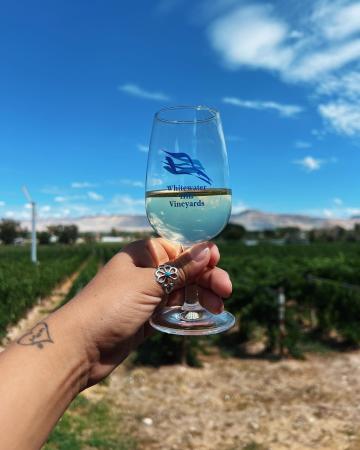 woman holding up a glass of wine at Whitewater Hill Vineyards
