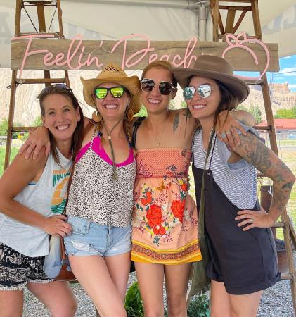 Girls Having a Fun time in front of a Feeling Peachy Sign