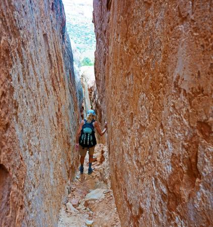 Woman Walking through a narrow Canyon