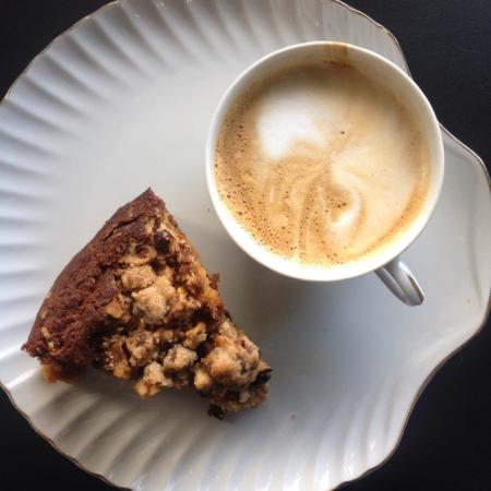 Top-down shot of scone on plate next to mug of foamy coffee from Bexley Coffee Shop