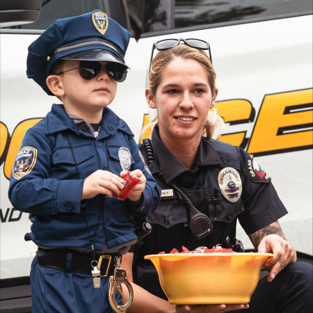 Kid in a Police Costume Standing Next to a Police Officer