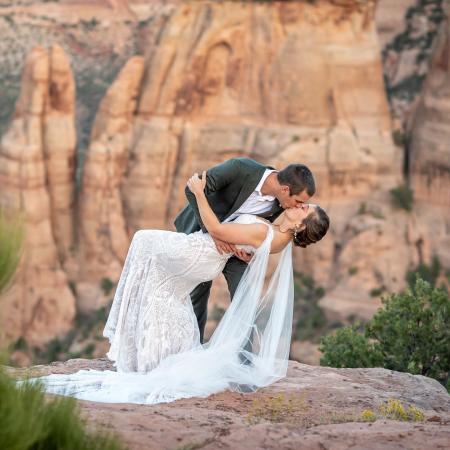 A recently married couple kissing in Colorado National Monument