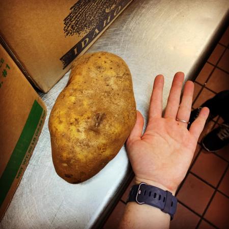 huge baked potato beside a hand at hebron grille in hebron ky