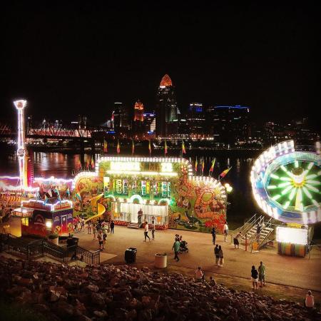 dark skyline behind illuminated food stand and festival rides during italianfest at newport ky