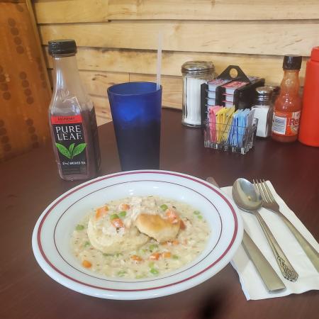 Chicken and biscuits in a white bowl with red trim and a raspberry tea bottle at Tucci’s Family Diner.