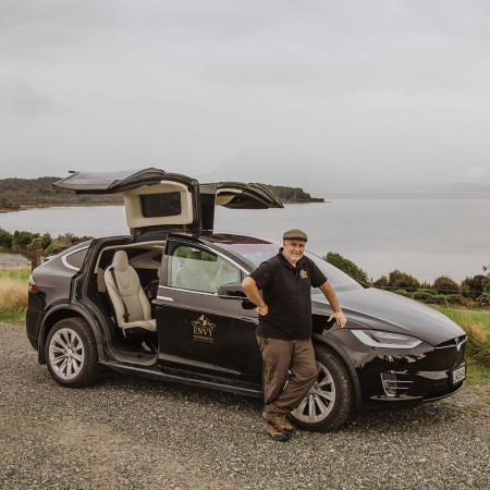 Nigel Humphries, owner of Envy Experiences standing in front of his Tesla