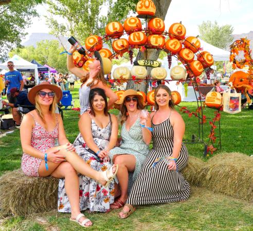Picture of Four Woman Sitting in Front of Pumpkin Sign