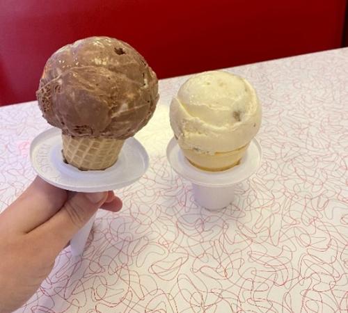 A chocolate and a vanilla scoop of ice cream in sugar cones