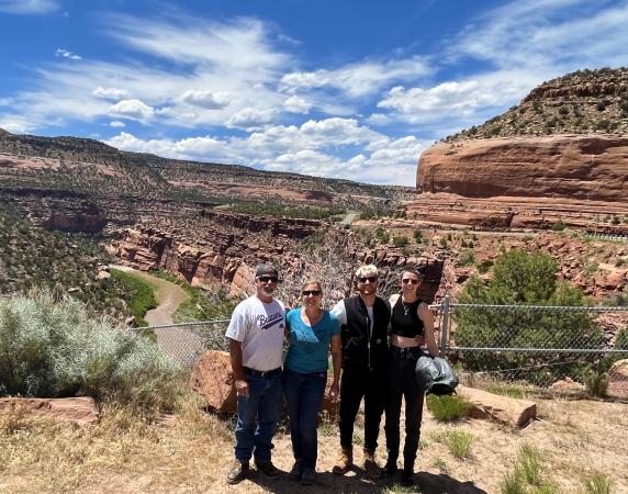 Picture of Four People Standing in Front of Mountains