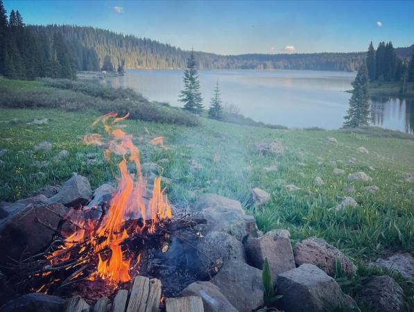 A campfire overlooking a lake in the Grand Mesa