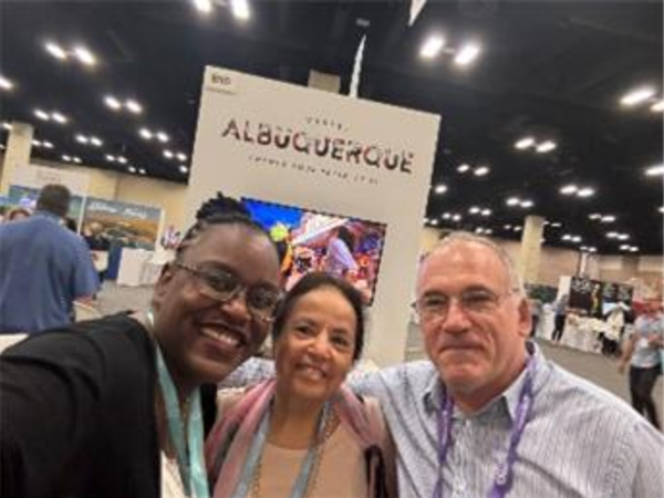 Tabitha and two others pose in front of Visit ABQ's booth at Cvent Connect