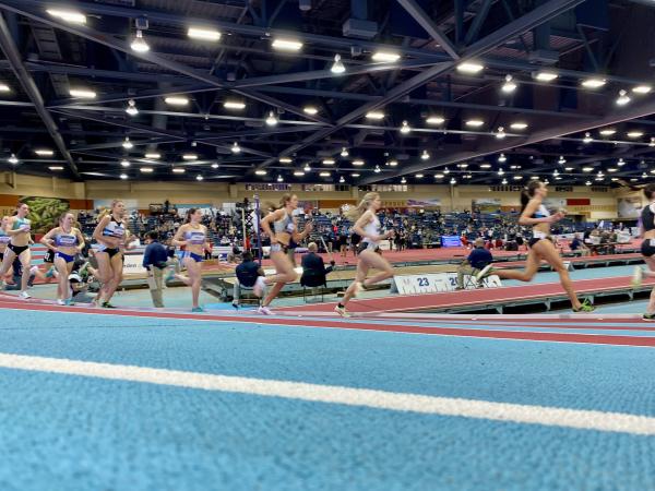 A few runners run on the track at the Albuquerque Convention Center competing in the USATF 2023 Indoor Track and Field Championships