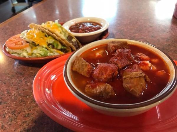 A bowl of pose with a plate of tacos from Barelas Coffee House.