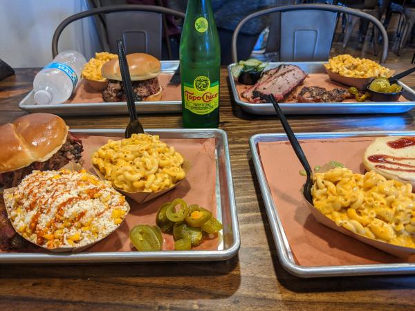 Photo of food trays at Hurtado Barbecue with sandwiches, corn and macaroni and cheese.