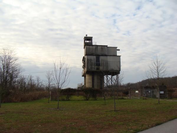 Historic industrial structure at the former Indiana Army Ammunition Plant in Charlestown, Indiana, surrounded by open grass and trees.
