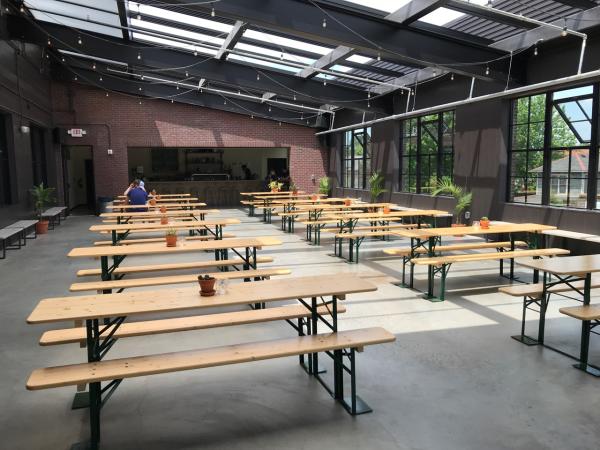 View of benches and bar under window pane ceiling inside Seventh Son Brewing's rooftop patio