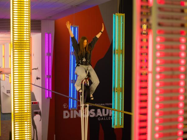 Woman riding high-wire unicycle at COSI