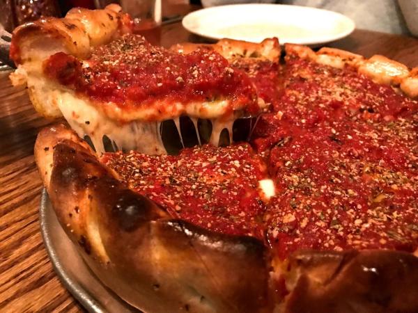 Spatula cutting slice of Chicago-style deep dish pizza from Yellow Brick Pizza