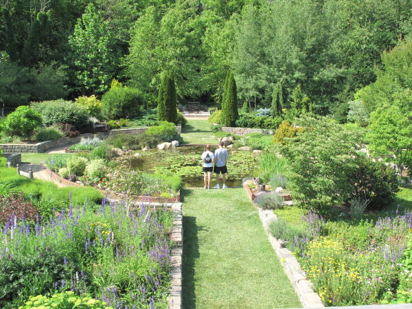 Two young people stand in front of a pond in a garden in Goshen, Indiana