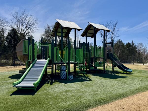 Small squares of sheet-metal provide shade for a green playground at Celebration Wellness Park.