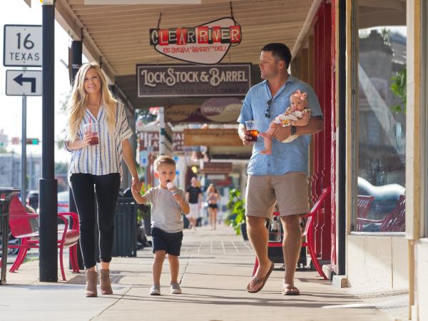 A family walks down Main Street in Fredericksburg, TX