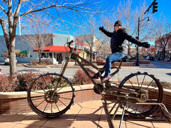 Woman Sitting on Large Bike Sculpture in Downtown Grand Junction