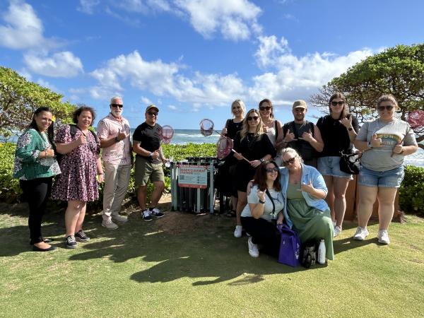 Mike Masterson of the Outrigger Kauaʻi Beach Resort shows the group their beach clean-up station for guests to Mālama the beach.