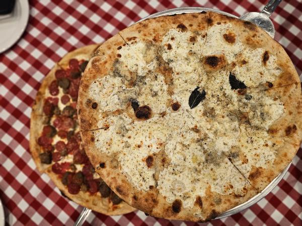 Red and white checkered tablecloth with two pizzas