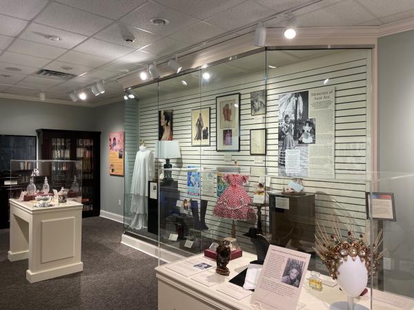 Side shot of the collections showcase exhibit featuring large case and two smaller cases full of artifacts