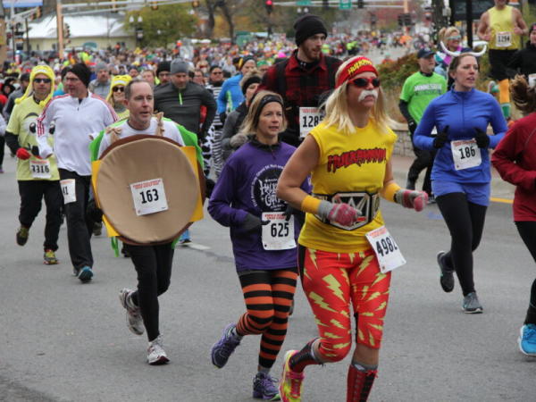 Costumed runners compete in a race during Anoka Halloween