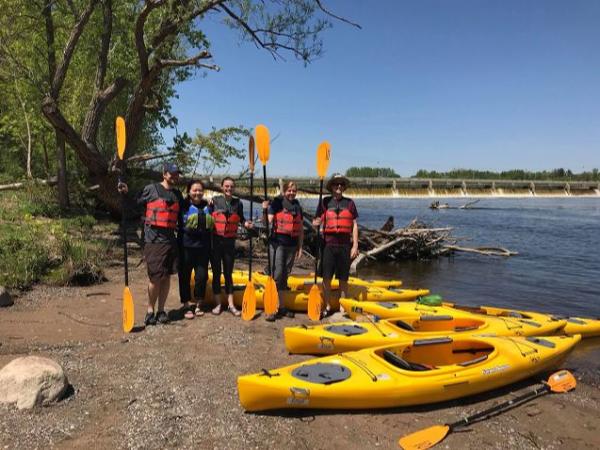 Kayaking group on the shore with paddles