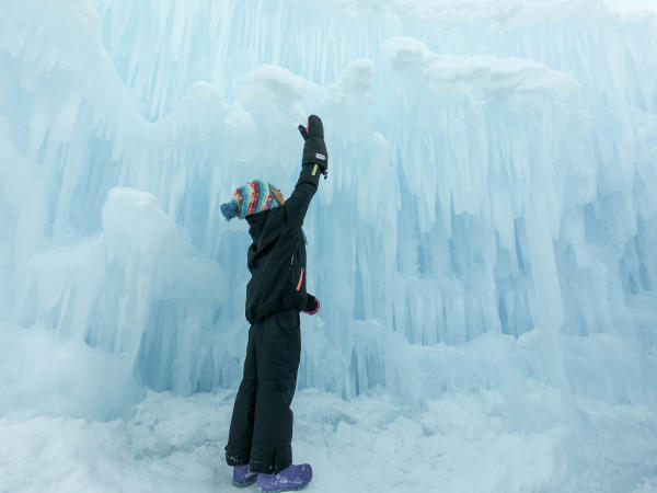 Young boy looking up at an ice wall