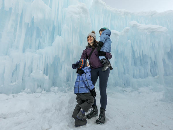 Mother with two children in front of ice castle wall