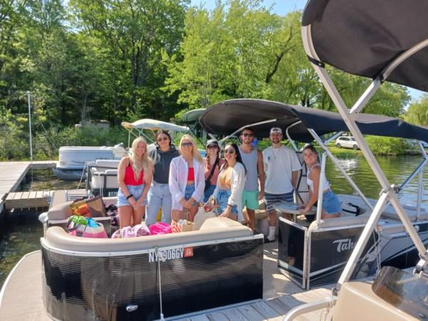 Group of people standing to post on pontoon on the lake