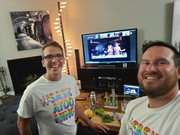 two men watching TV and having cocktails.