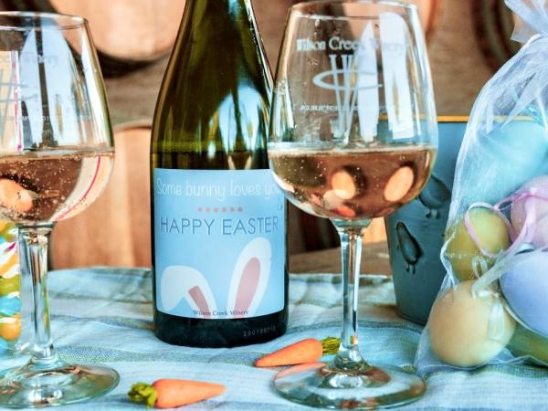 Wine glasses and wine bottle from Wilson Creek Winery next to colorful easter eggs