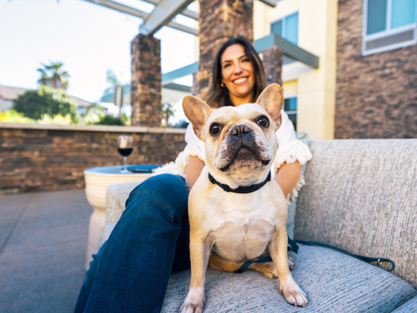 A dog and woman sitting in an outdoor patio at the Hilton Garden Inn in Temecula, CA
