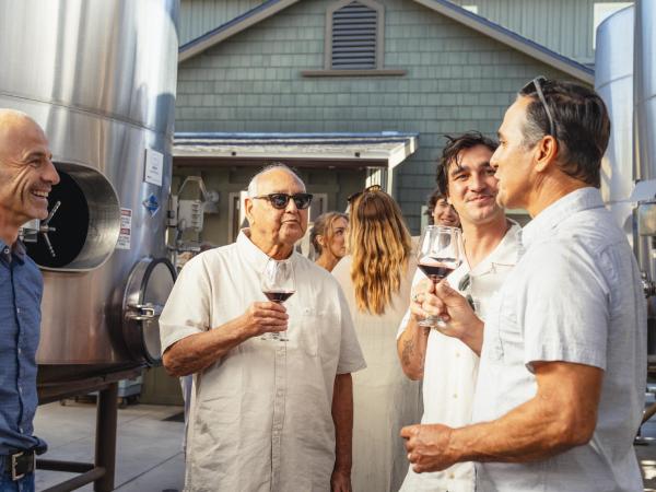Men Gathered by Winery Production Tanks