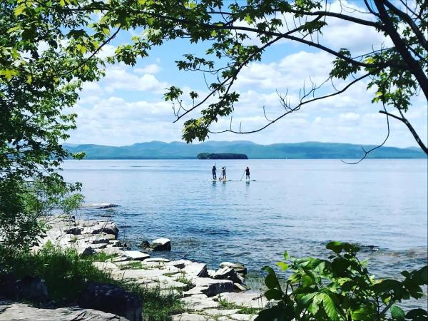 Three people paddleboard on Lake Champlain