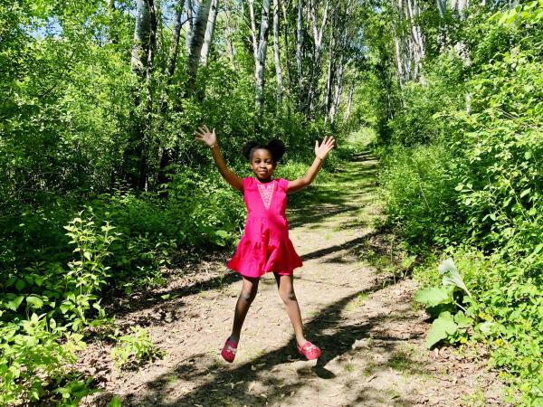 Girl jumping up on nature trail