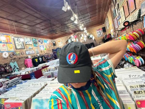 Person Showing off Hat in Triple Play Records